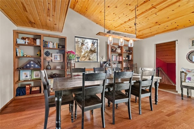 dining space with baseboards, wood finished floors, high vaulted ceiling, and wooden ceiling