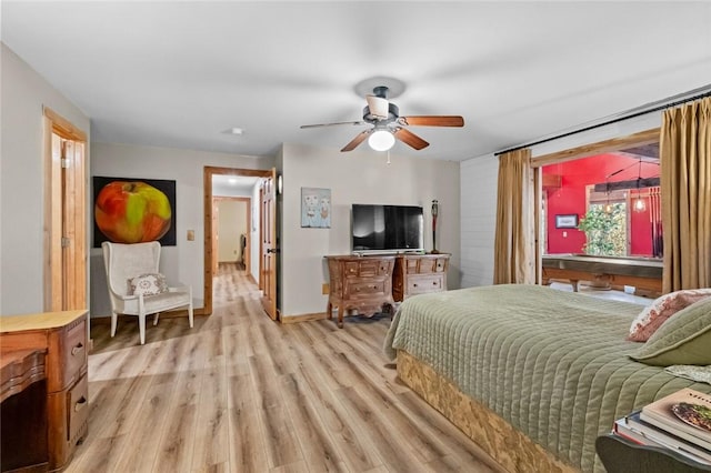 bedroom with a ceiling fan, baseboards, and light wood-type flooring