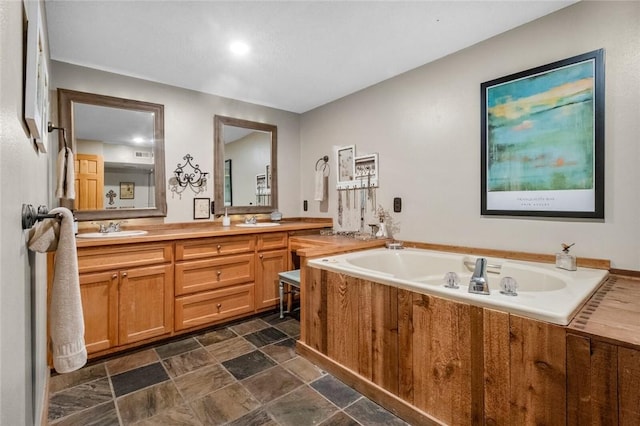 bathroom featuring double vanity, stone finish floor, a bath, and a sink