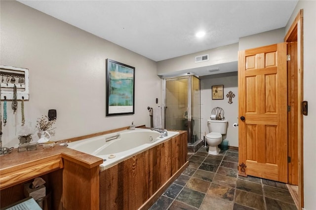 full bath with visible vents, stone finish flooring, toilet, a stall shower, and a bath