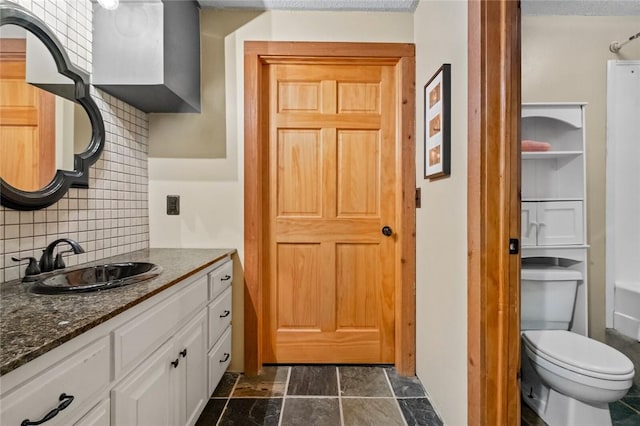 full bath with tasteful backsplash, toilet, and vanity