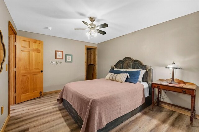 bedroom featuring baseboards, light wood-type flooring, and ceiling fan