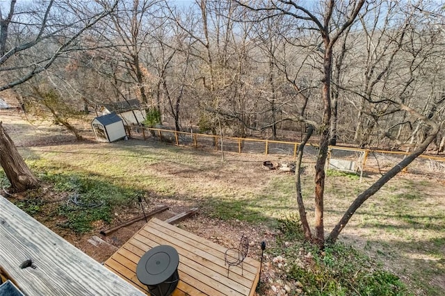 view of yard featuring a storage shed, an outbuilding, and fence