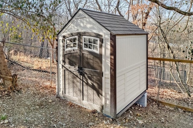 view of shed featuring fence