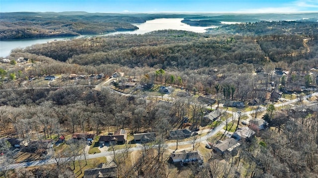 drone / aerial view with a wooded view and a water view