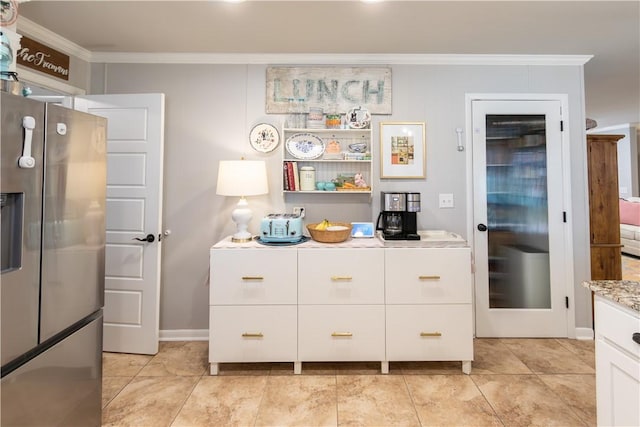 kitchen with light tile patterned floors, white cabinetry, light countertops, and ornamental molding