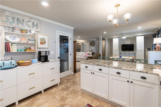 kitchen featuring recessed lighting, open floor plan, white cabinets, and crown molding