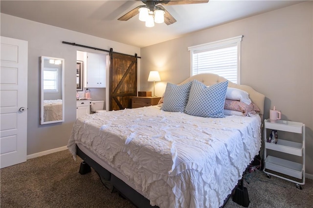 carpeted bedroom with connected bathroom, baseboards, a barn door, and a ceiling fan