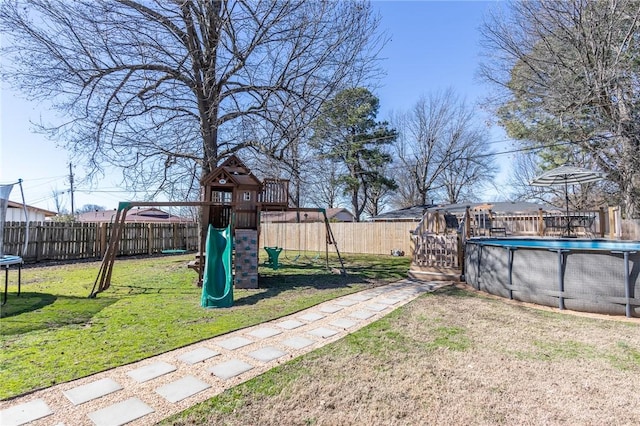 view of yard with a playground, a trampoline, a fenced in pool, and a fenced backyard