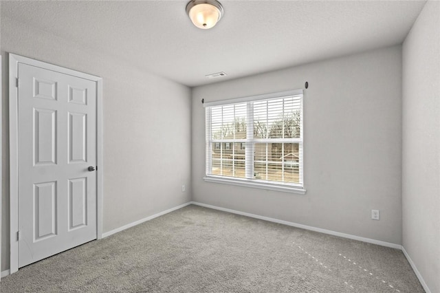 unfurnished bedroom with carpet, visible vents, and baseboards