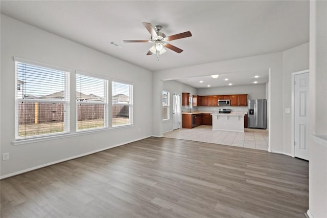unfurnished living room featuring baseboards, recessed lighting, a ceiling fan, visible vents, and light wood finished floors