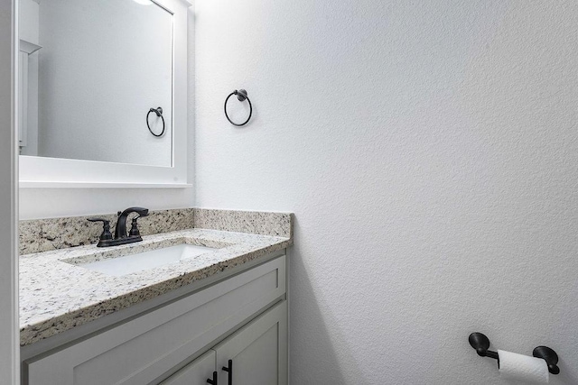 bathroom featuring a textured wall and vanity