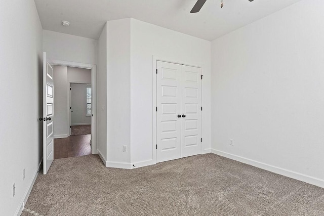 unfurnished bedroom with a ceiling fan, carpet, a closet, and baseboards