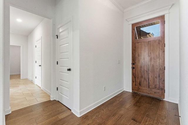 entryway featuring crown molding, baseboards, and wood finished floors