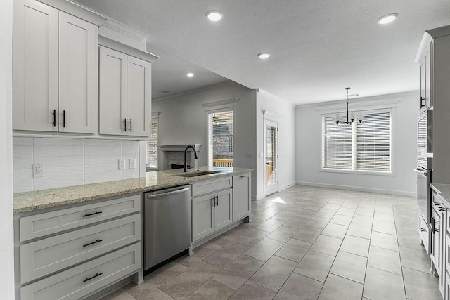 kitchen with stainless steel appliances, a sink, ornamental molding, decorative backsplash, and light stone countertops