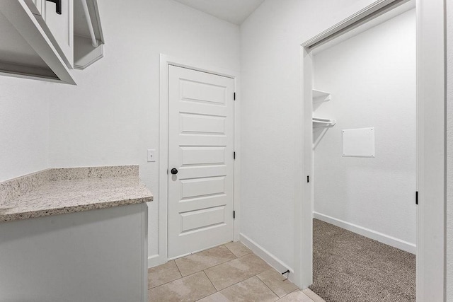 laundry room featuring light tile patterned flooring and baseboards