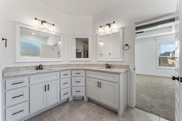 full bath with double vanity, a sink, and tile patterned floors