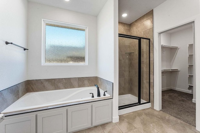 full bathroom with a garden tub, a spacious closet, a shower stall, and recessed lighting