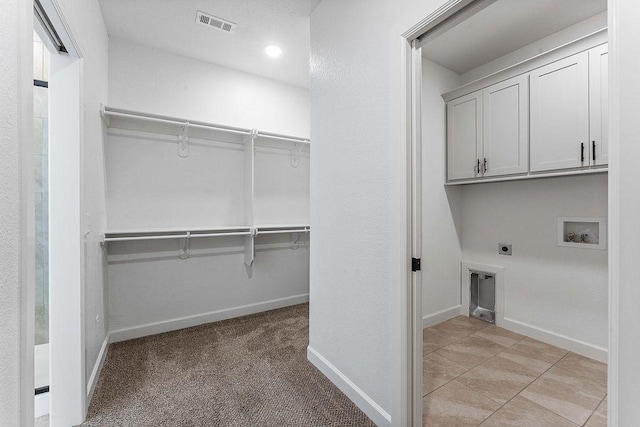 laundry area with hookup for a washing machine, cabinet space, visible vents, hookup for an electric dryer, and baseboards