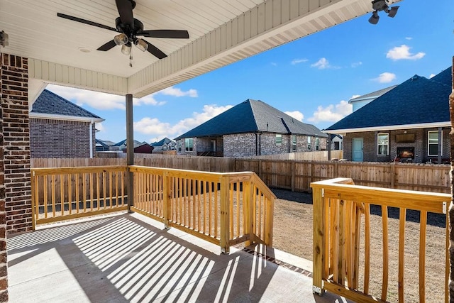 wooden deck with a ceiling fan, a residential view, and a fenced backyard