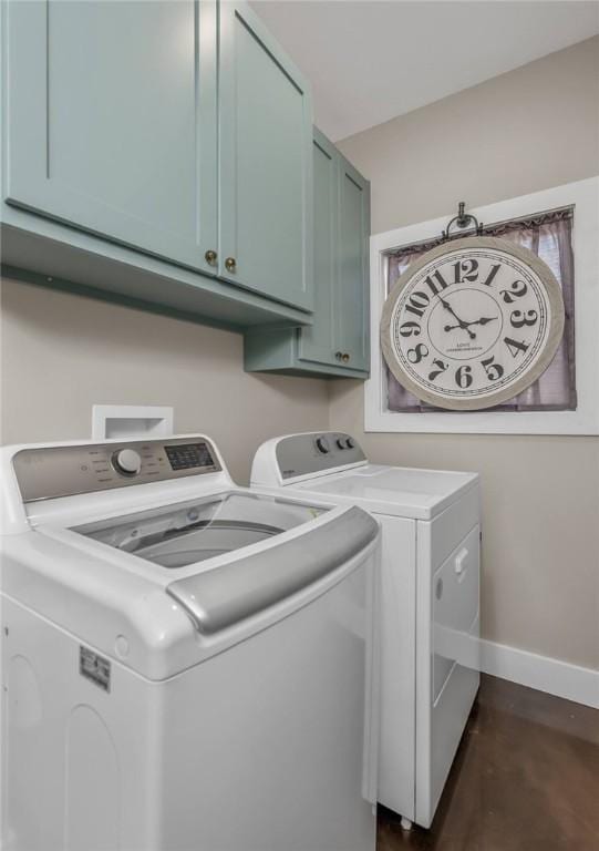 washroom with cabinet space, baseboards, washer and clothes dryer, and dark wood-style flooring