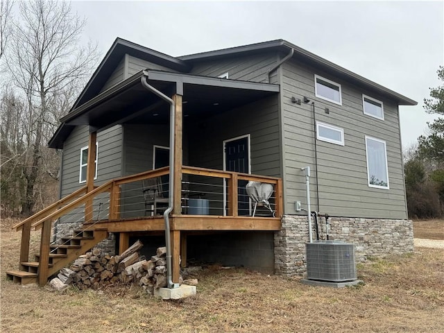 back of property featuring stairway and cooling unit