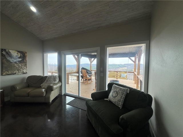 sitting room featuring finished concrete floors and vaulted ceiling