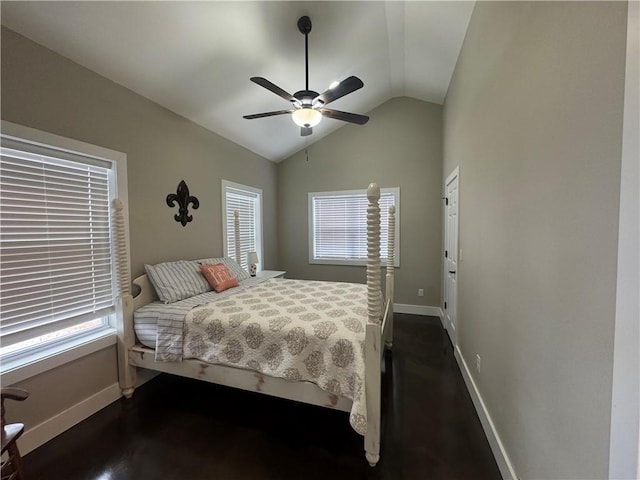 bedroom featuring lofted ceiling, multiple windows, and baseboards