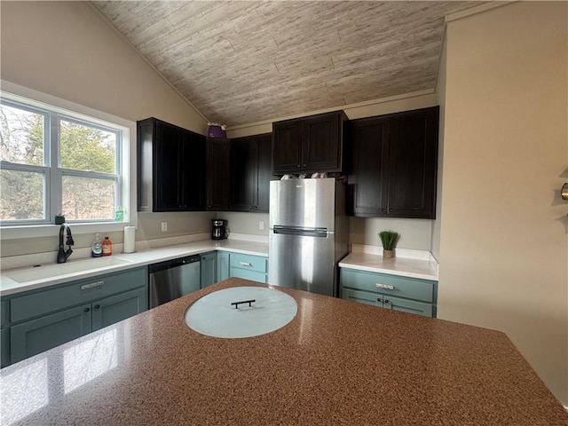 kitchen with vaulted ceiling, stainless steel appliances, wooden ceiling, and a sink