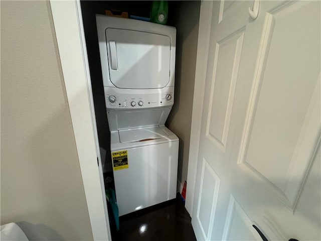 clothes washing area with laundry area and stacked washing maching and dryer