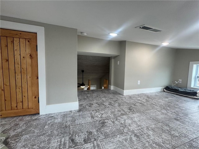 unfurnished living room featuring visible vents, ceiling fan, and baseboards