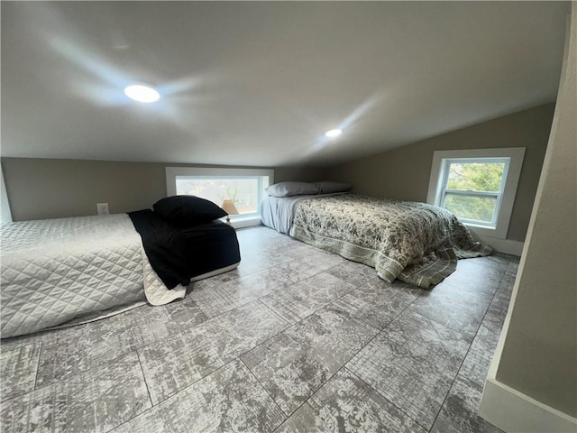 bedroom featuring vaulted ceiling, multiple windows, and baseboards