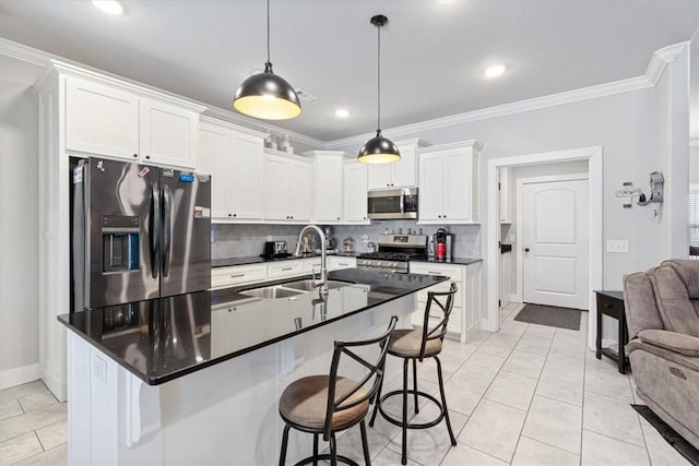 kitchen featuring stainless steel appliances, dark countertops, a sink, and crown molding