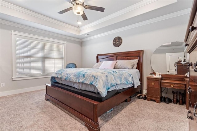 carpeted bedroom featuring a ceiling fan, a raised ceiling, crown molding, and baseboards