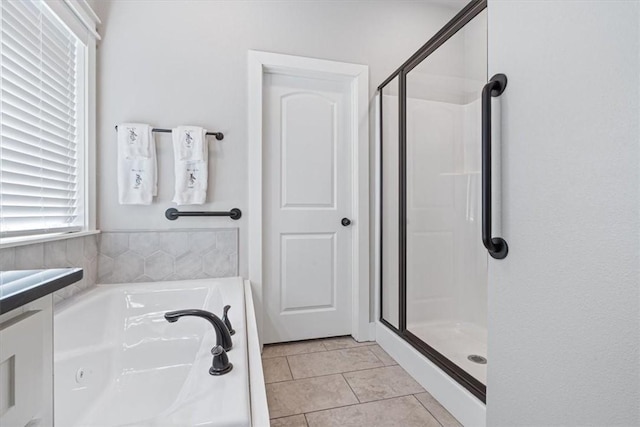 full bath featuring tile patterned flooring, a shower stall, and a bath