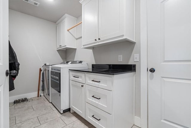 laundry area featuring cabinet space, visible vents, light tile patterned flooring, washer and dryer, and baseboards