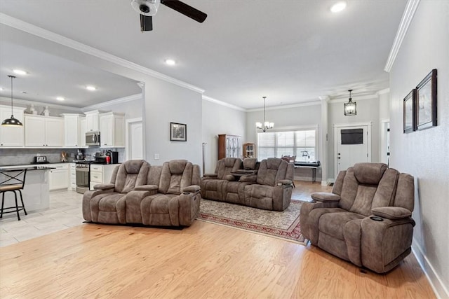 living area with light wood-style flooring, recessed lighting, ceiling fan with notable chandelier, baseboards, and crown molding