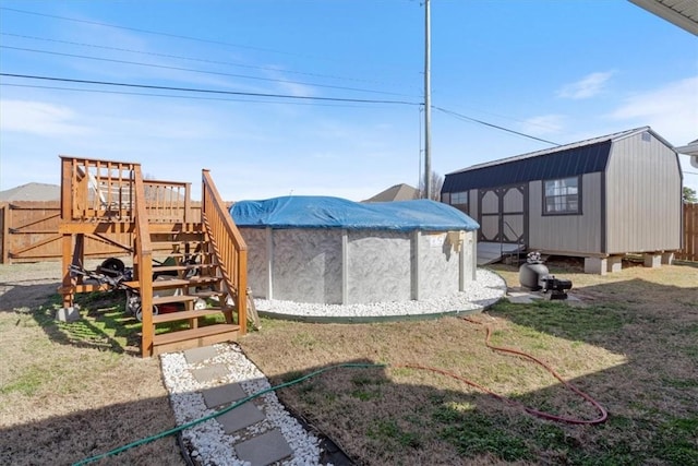 view of yard featuring a storage shed, an outbuilding, fence, and a covered pool