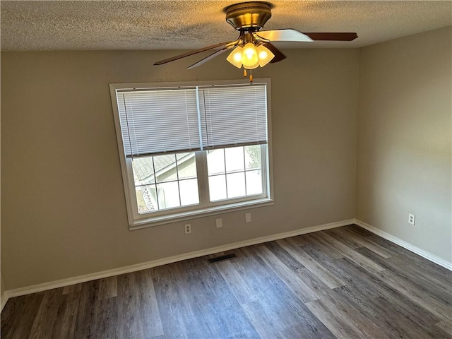 spare room featuring baseboards, visible vents, ceiling fan, wood finished floors, and a textured ceiling