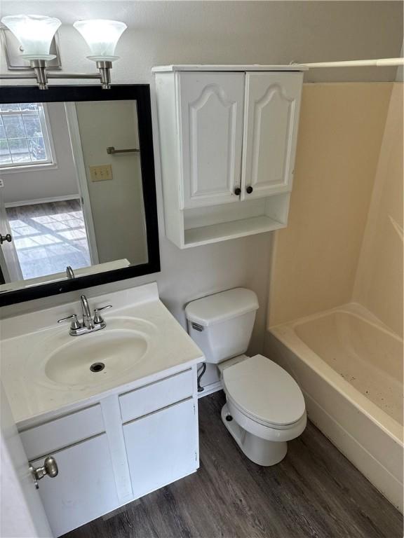 bathroom featuring vanity, wood finished floors, and toilet