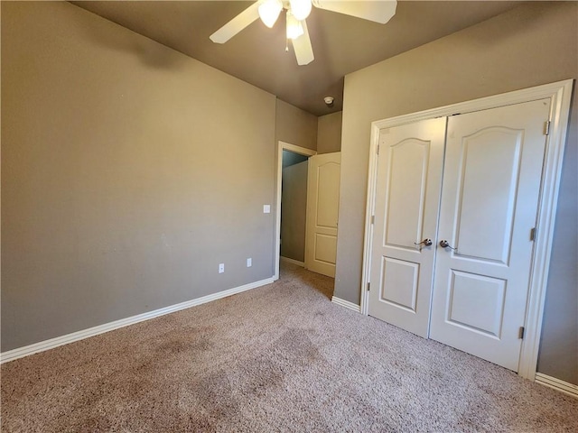 unfurnished bedroom featuring ceiling fan, a closet, baseboards, and carpet flooring