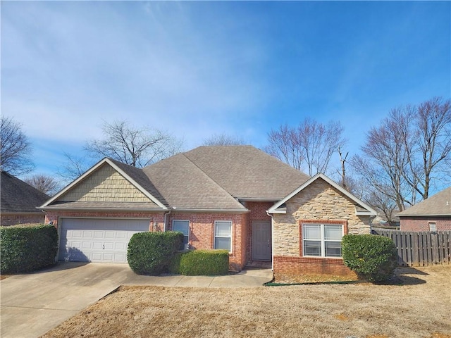 view of front of home with brick siding, fence, driveway, and an attached garage