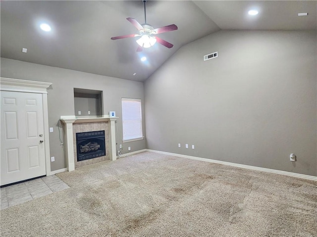 unfurnished living room with visible vents, a tiled fireplace, a ceiling fan, carpet flooring, and vaulted ceiling