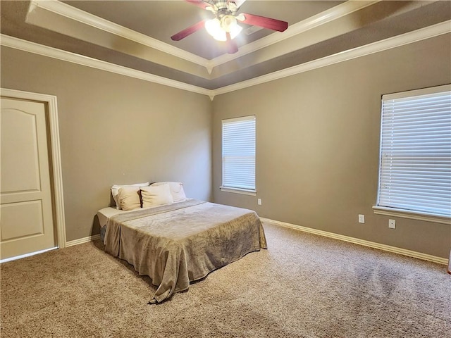 carpeted bedroom featuring ornamental molding, a raised ceiling, and baseboards