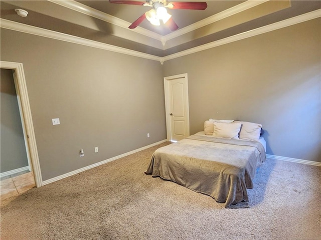 carpeted bedroom featuring ornamental molding, a tray ceiling, a ceiling fan, and baseboards