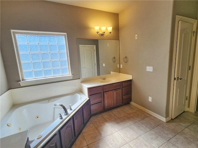 bathroom with a tub with jets, tile patterned flooring, vanity, and baseboards