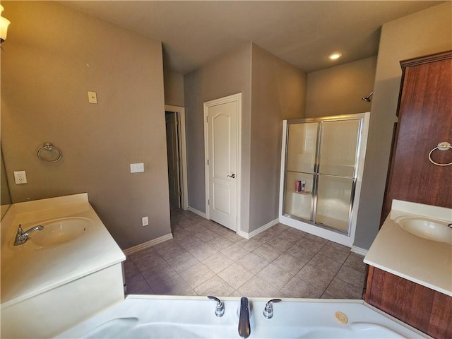 bathroom featuring tile patterned floors, vanity, a shower stall, baseboards, and a bath