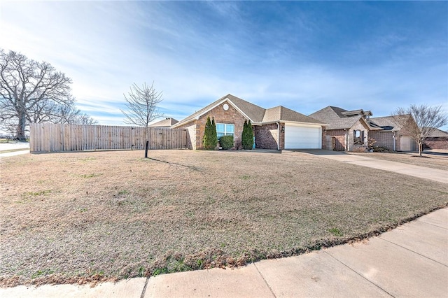 view of front of house with brick siding, an attached garage, a front yard, fence, and driveway