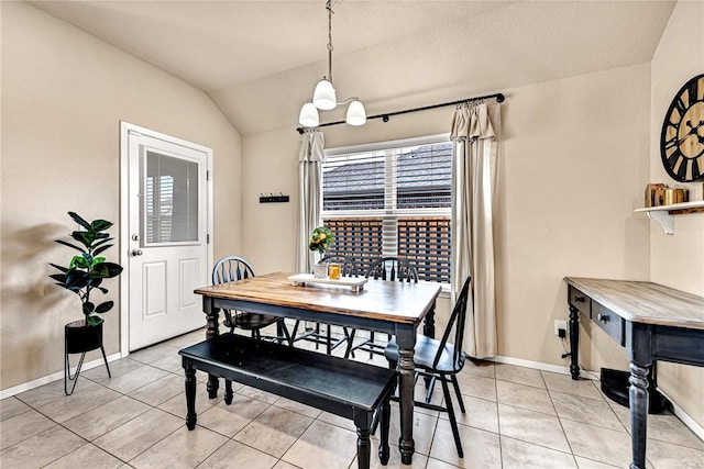 dining room with lofted ceiling, light tile patterned floors, and baseboards