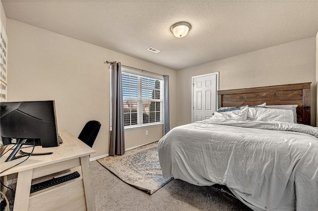 bedroom with carpet, visible vents, a textured ceiling, and baseboards